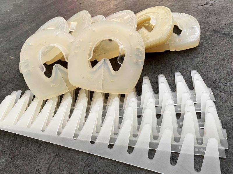 Eight Dummy Plastic Fittings and Eight Adhesive Collars Resting on Concrete Floor