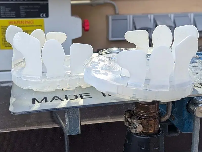 Des fers collés finis sont composés d’une plaque de base et d’une manchette à coller Basic. Ils reposent sur un dispositif de soudure.