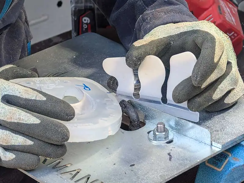 Une maréchale-ferrante soude une plaque de base avec une manchette à coller Basic pour créer un fer collé. Elle utilise un dispositif de soudage dédié.