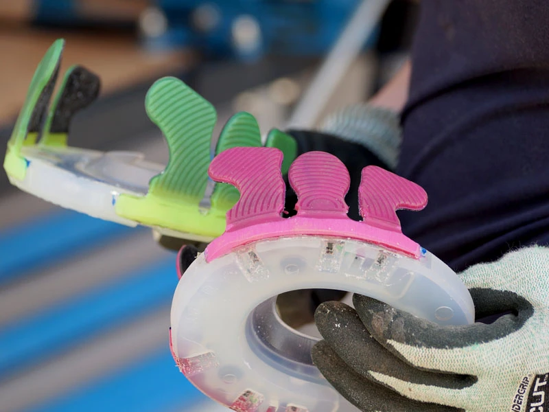 Detailaufnahme der fertigen Klebeeisen mit pinken und grünen Klebelaschen und dem Nailless als Grundplatte