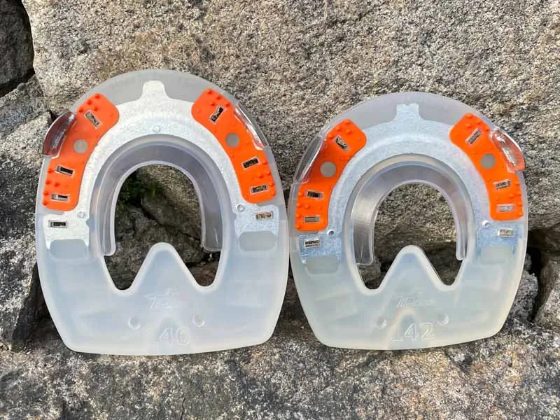 Ferri di cavallo a sangue freddo particolarmente stabili, di forma rotonda e ovale, si trovano davanti a un muro di pietra.