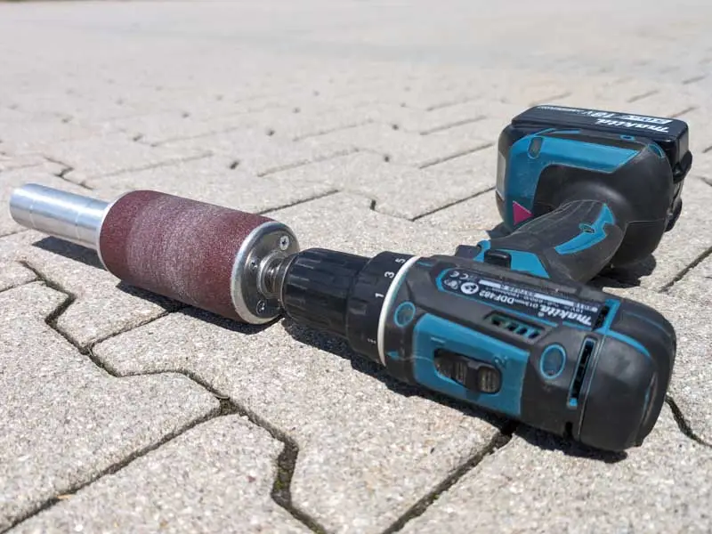 hoof buffer in un avvitatore a batteria si trova sulle pietre della pavimentazione