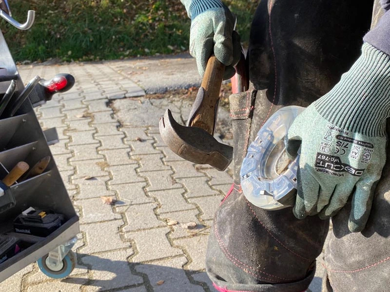 Un maniscalco inchioda un ferro di cavallo su uno zoccolo con un martello per ferratura Dick con manico in hickory