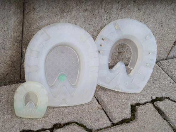 Fers synthétiques amortissants pour chevaux dans trois versions différentes, présentés côte à côte.