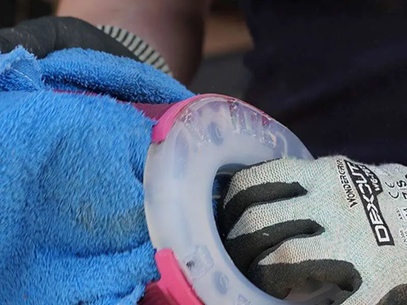 Farrier wipes the foam cleaner off the horseshoe with a towel