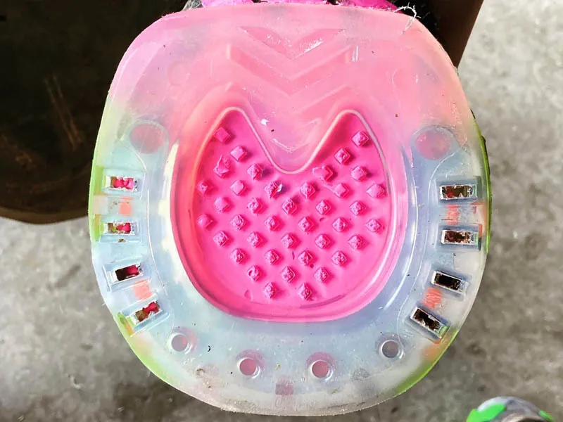 Herraduras compuestas con suela cerrada y almohadilla rosa.