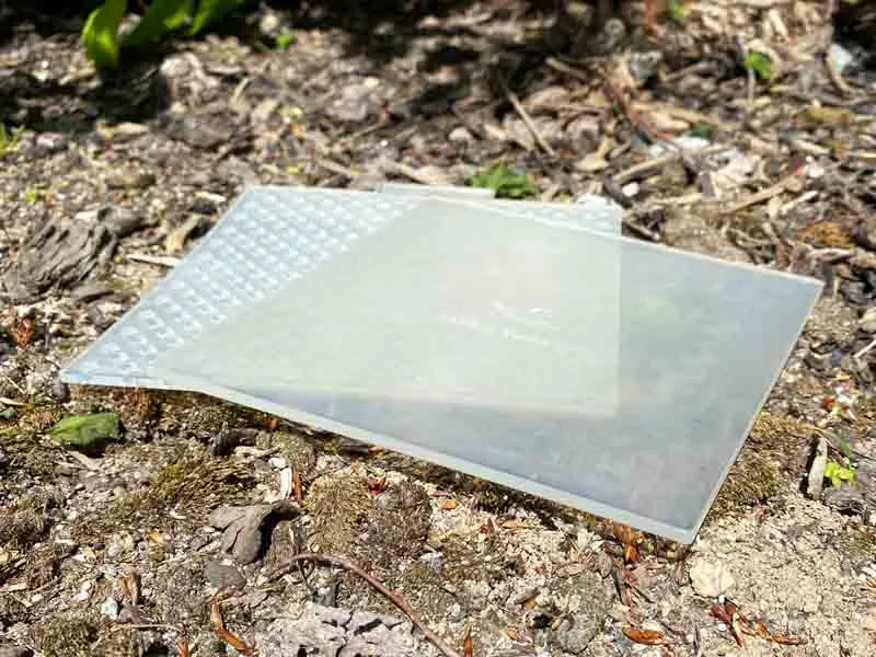 Placas cuadradas de plástico están sobre piedras.