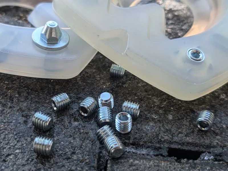 composite horseshoe with studs for ice and snow in Nordic countries and blank studs lying on rocks in winter