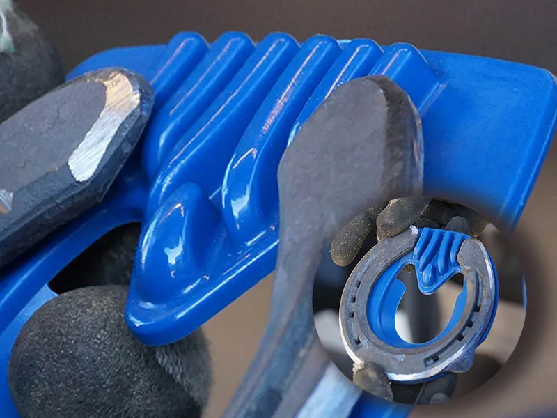 Se observa una toma de detalle del soporte de ranilla de la tapa azul entre las ramas de una herradura Mustad. En un pequeño recorte circular, se muestra la tapa dentro de la herradura después de haber sido modificada para un ajuste preciso.