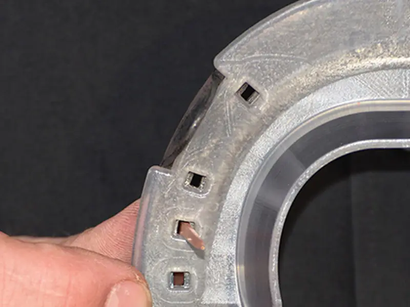 El herrador demuestra que las claveras de la tapa KC se alinean perfectamente con el modelo de herradura Comfort de la marca Kerckhaert, insertando un clavo a través de ellas.