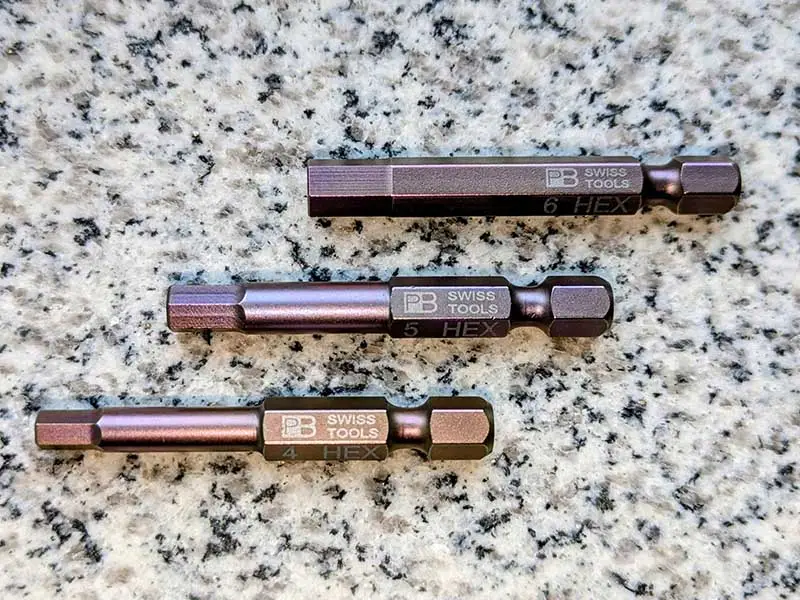tre diverse dimensioni del PrecisionBit di Swiss Tools, forma E 6,3 1/4 pollice, su una lastra di pietra
