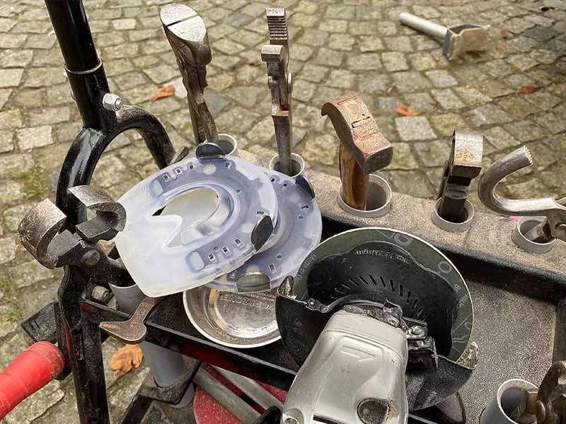 Chariot à outils pour le ferrage avec tenailles, marteau, meuleuse d’angle et fers à cheval alternatifs.